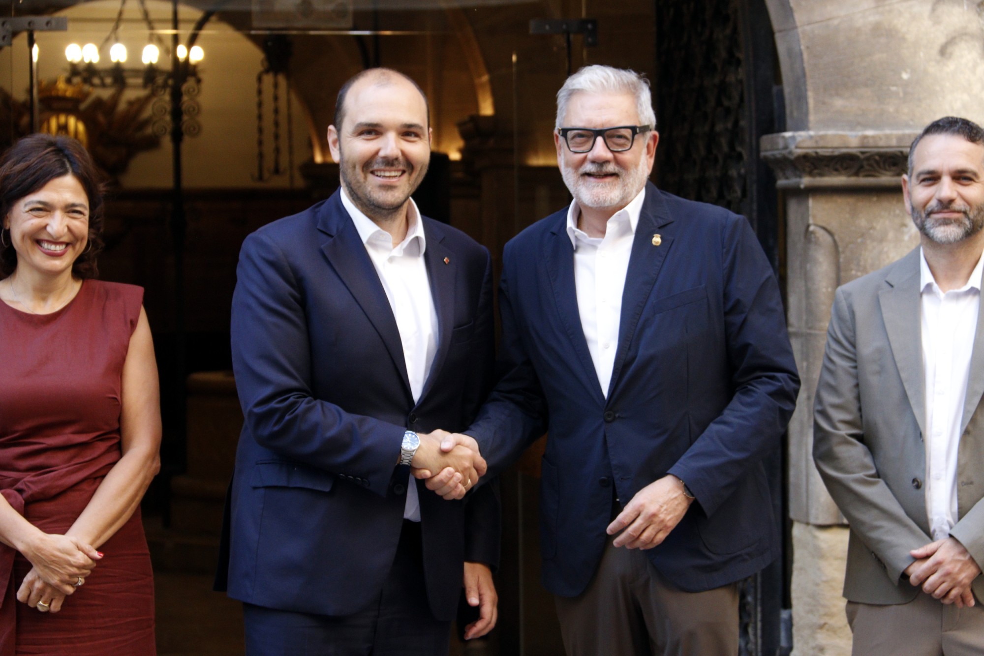 El conseller de la Presidència, Albert Dalmau, i l'alcalde de Lleida, Fèlix Larrosa, encaixen les mans al davant del Palau de la Paeria abans de l'inici de la reunió bilateral entre la Generalitat i l'Ajuntament de Lleida