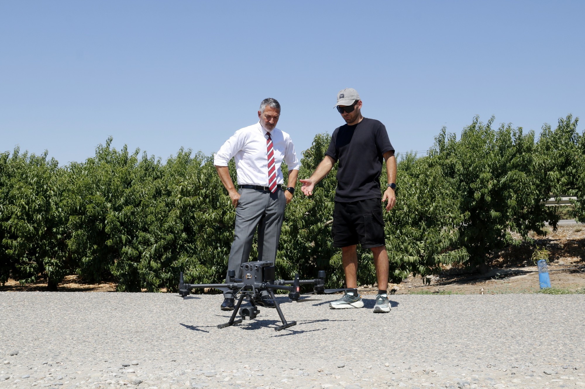 El conseller Miquel Sàmper mira el dron utilitzat per mirar com es treballa al camp